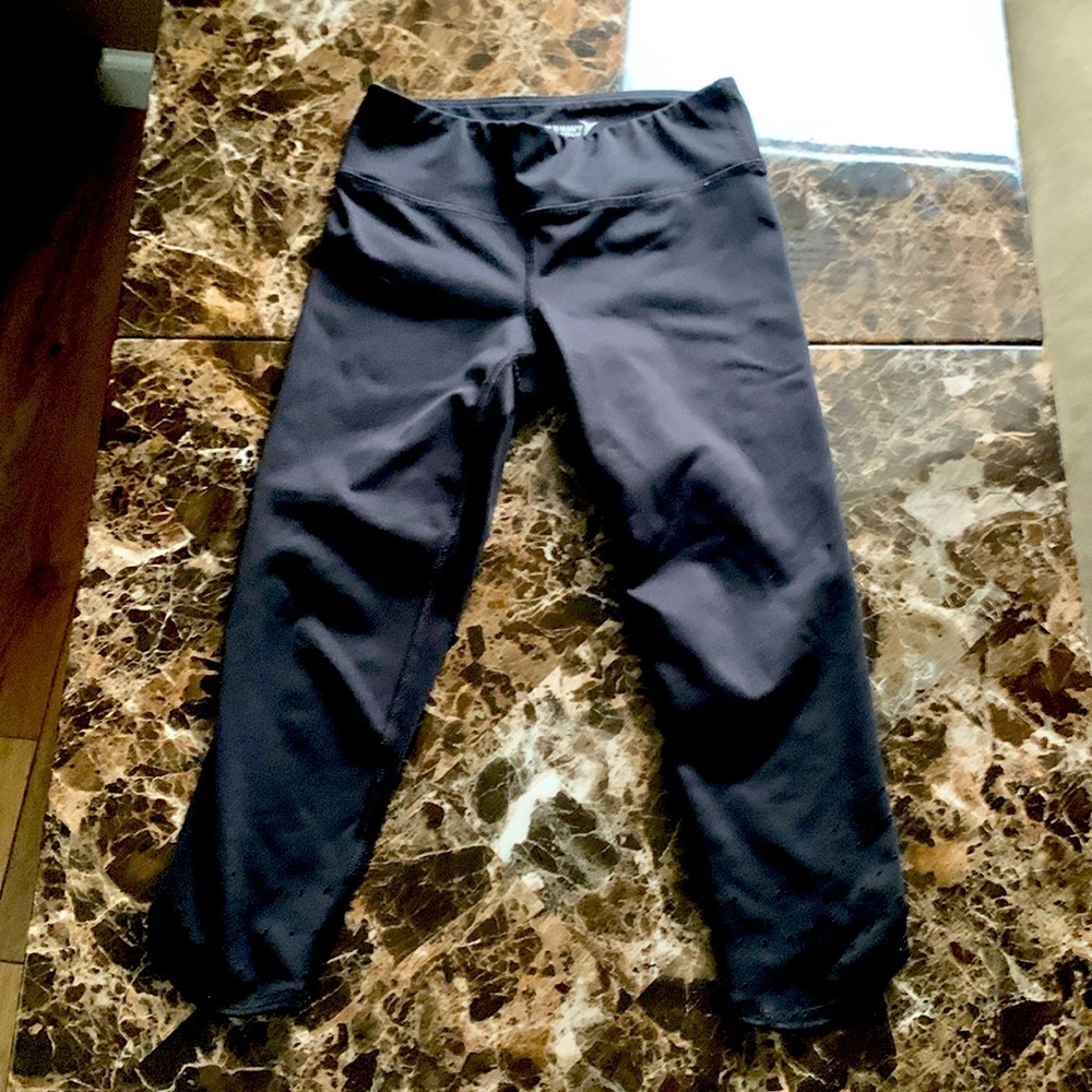 A black pair of leggings with holes at the bottom